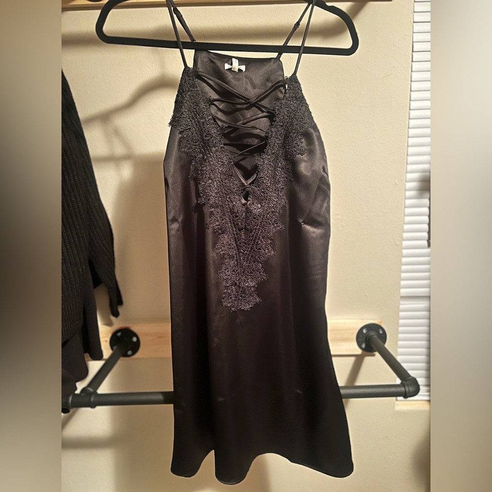 Black silky dress with criss cross and lace front. New with tags. Size medium.